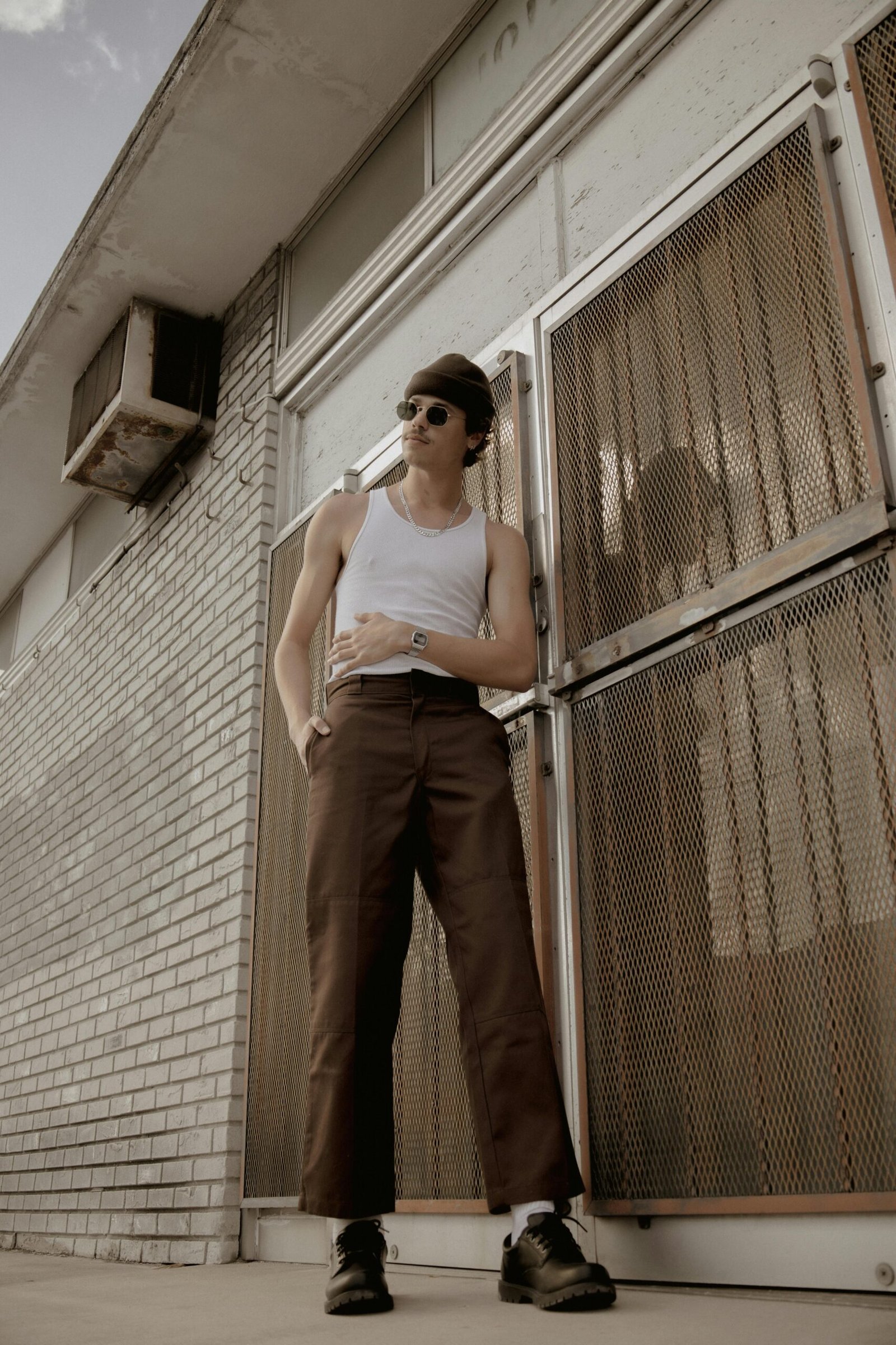 Stylish male model in urban setting, showcasing retro fashion and cool vibes.